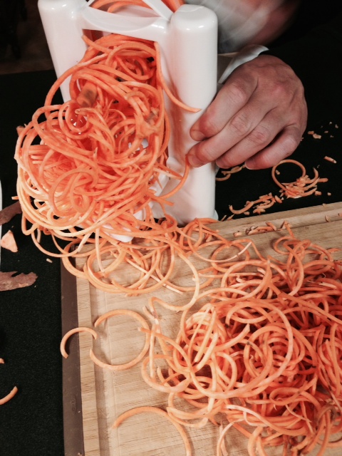 Rob's man handling the sweet potatoes through the Spirilizer